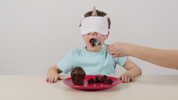 Kleine Jongen Een Masker Probeert Raadt Chocolade Muffin — Stockvideo