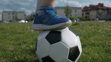 Futbolcu bir ayağı futbol sahasında duruyor. Eğil.