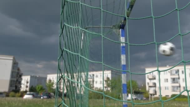劇的な空の背景にネットにサッカーのサッカーボールの目標 スローモーション — ストック動画