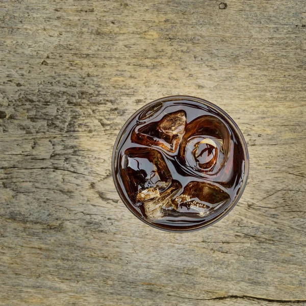 Cola in het glas met ijs van bovenaanzicht op houten Stockfoto