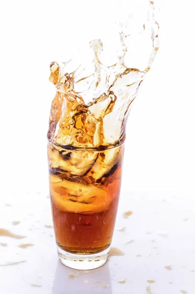 Ice cube droped i cola glas och cola stänk. — Stockfoto