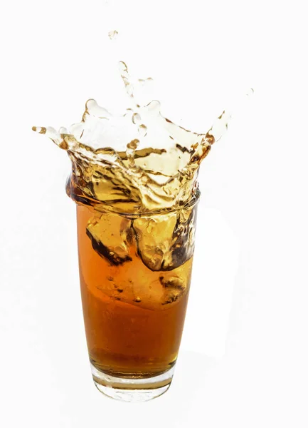 Cubo de hielo caído en vidrio de cola aislado — Foto de Stock