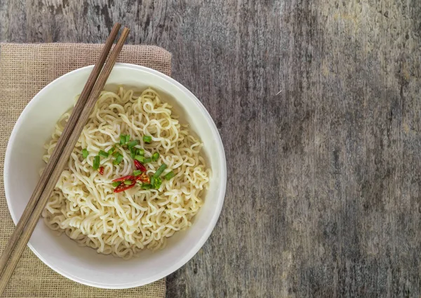 Fideos instantáneos en tazón sobre madera . Imagen de stock