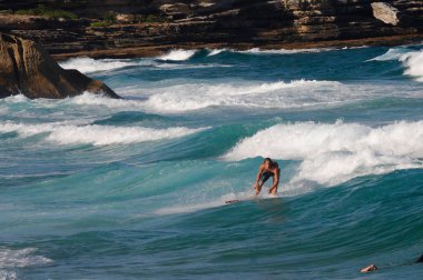 Sidney, Avustralya 'da Bronte Beach' te sörf yapan bir sörfçü.