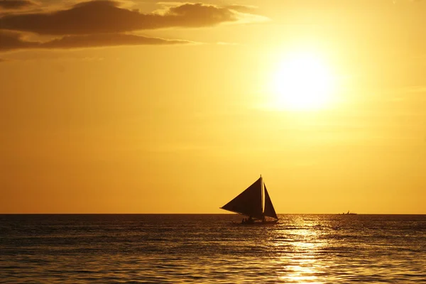 黄色の夕日を背景に海上を航海する帆船 — ストック写真