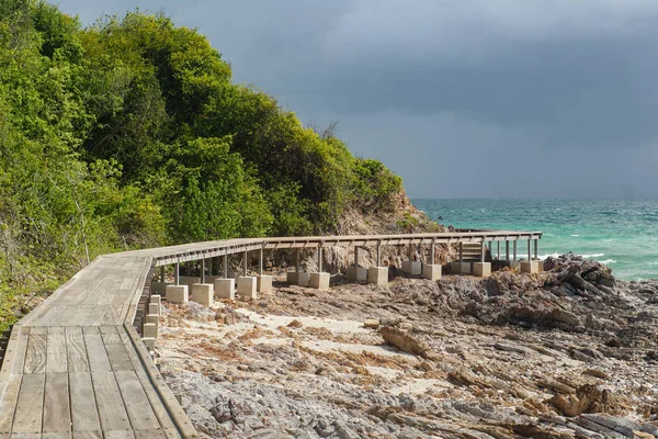 在雷雨的背景下 海滨岩石上的木制人行桥 — 图库照片