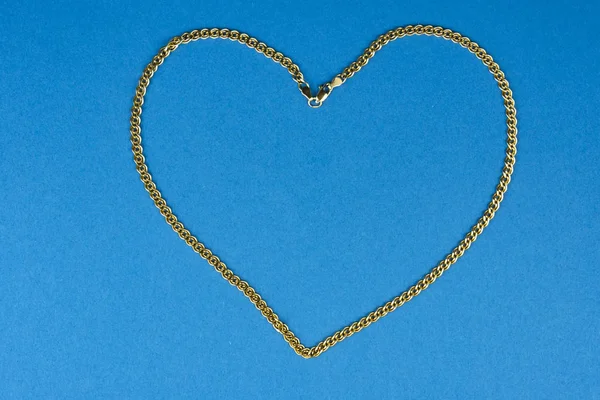 Heart shaped red gold chain on a blue background.