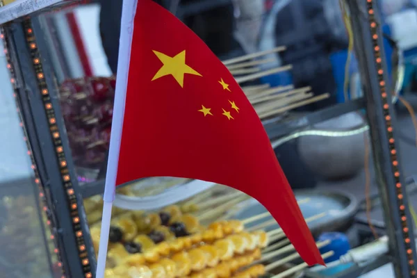 Chinese flag on a background of trolleys with sweets.