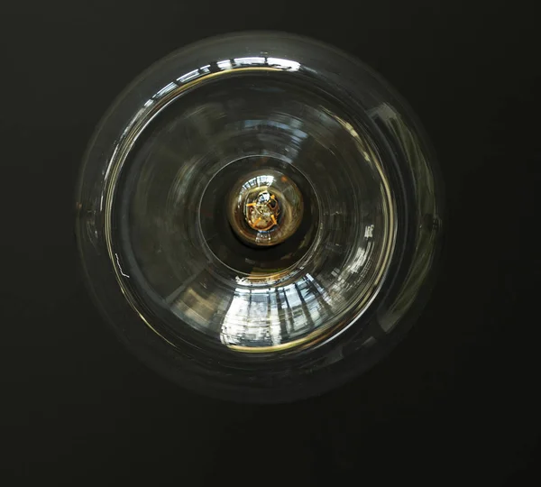 Edison lambası cam bir kabukta, karanlık bir duvara karşı, alt manzara..