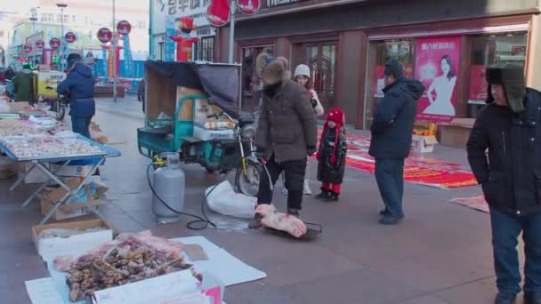 2020年1月4日 中国人が冬に豚頭の半分に火を注ぐ — ストック動画