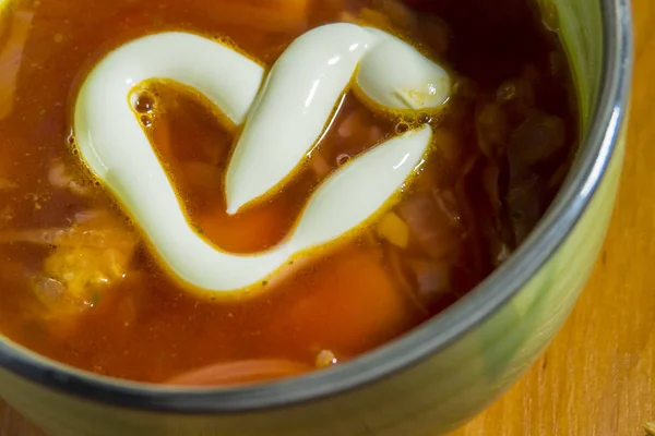 A bowl of red borsch with heart-shaped mayonnaise — 스톡 사진