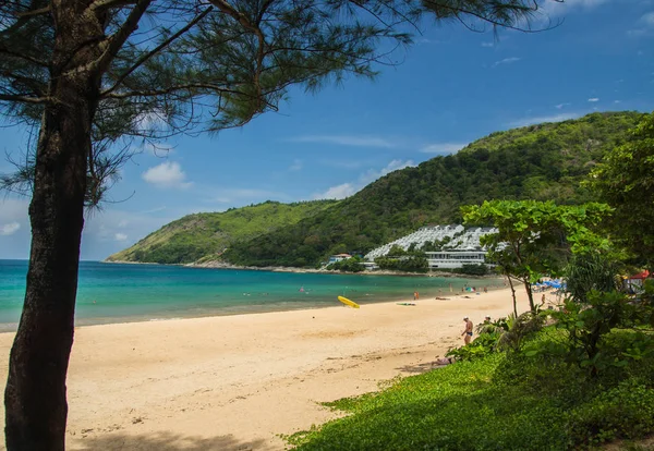 Phuket, Tayland - 19 Nisan 2017. Önünde büyük taşlar olan kumlu bir sahil, yeşil bir tepe ve beyaz bir otel..