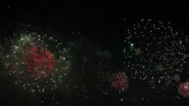 Karanlık gökyüzüne karşı farklı şekillerde çok renkli havai fişekler, farklı boyutlarda planlar..