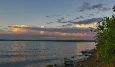 Baykal bölgesi. Yazın başında. Öğleden sonra. Gün batımı. Kümülüs bulutları üzerinde yüzen büyük bir gölün su yüzeyinde yansıyor. Boş alan