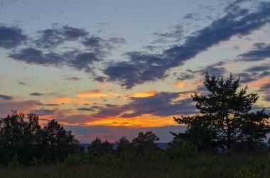 Doğu Sibirya. Baykal bölgesi. Hacimli pembe ve turuncu tüy bulutlarıyla güzel bir yaz günbatımı. Boş yer