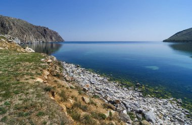 Doğu Sibirya. Baykal Gölü. Aya Körfezi. Şeffaf sıcak yaz günü. Dik kayalıklar. Sudaki yansımalar. Haze. Hava sıcaklığı + 37 santigrat derece, su sıcaklığı + 8