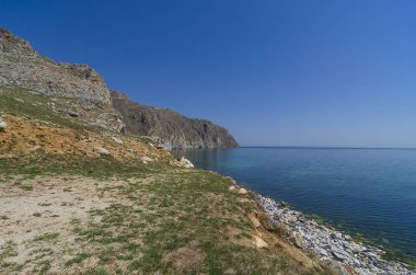 Doğu Sibirya. Baykal Gölü. Aya Körfezi. Şeffaf sıcak yaz günü. Dik kayalıklar. Sudaki yansımalar. Haze. Hava sıcaklığı + 37 santigrat derece, su sıcaklığı + 8