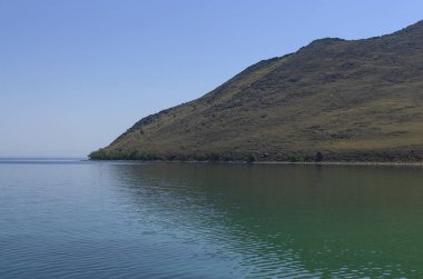 Doğu Sibirya. Baykal Gölü. Aya Körfezi. Şeffaf sıcak yaz günü. Dik kayalıklar. Sudaki yansımalar. Haze. Hava sıcaklığı + 37 santigrat derece, su sıcaklığı + 8
