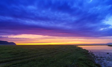 Doğu Sibirya. Baykal Gölü. Bolshoy Goloustnoye köyü. Güzel gün doğumu. Bir sürü kümülüs bulutu.