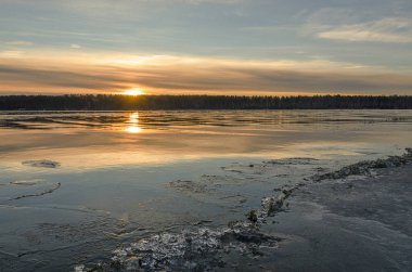 Sibirya 'da. Baykal bölgesi. Sonbaharın sonunda. Irkutsk Körfezi 'nin üzerinde güzel bir gündoğumu. Pembe, turuncu, sarı, suda mavi yansımalar. Çimlerde buz var. Sahil boyunca buz