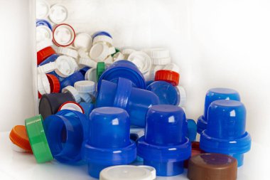 Beyaz arkaplanda geri dönüşüm için renkli plastik kapaklar