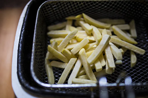 Frying chips in a white kitchen fryer — Stock Photo, Image
