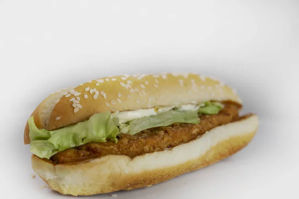 Kızarmış tavuk burger, marul ve mayonez, beyaz arka planda, yemek konsepti.
