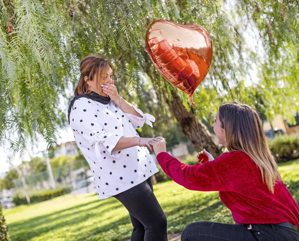 lezbiyen kız kalp şeklinde balon kıza evlenme teklif ediyor, şaşırmış kız, yaşam tarzı konsepti