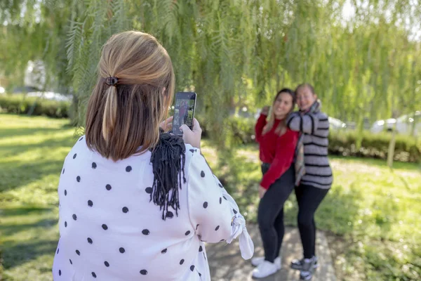 Kız, açık hava parkında iki kızın fotoğrafını çekiyor, yaşam tarzı konsepti.