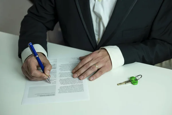 Takım elbiseli bir adamın ipotek kredisi imzalaması, finansal konsept