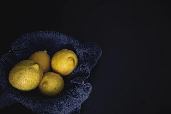 Koyu yiyecek arka planında dört limon ve metin için boşluk
