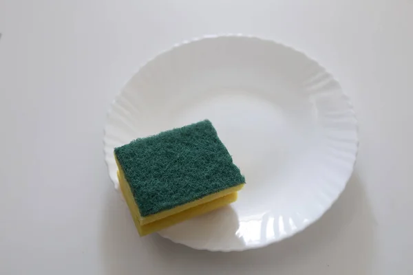 yellow and green scourer on a white plate