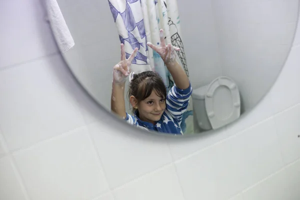Elinde köpüklerle beyaz bir kız, barış hareketiyle.