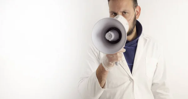 Doktor gibi giyinmiş bir adam megafonla konuşuyor.