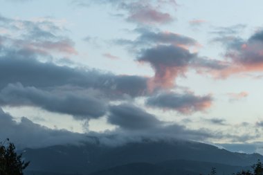 Dağlardaki yaz manzarası ve bulutlu koyu mavi gökyüzü.