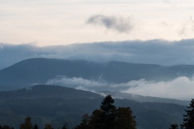 Dağlardaki yaz manzarası ve bulutlu koyu mavi gökyüzü.