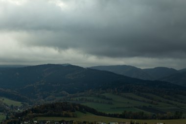 Dağlardaki yaz manzarası ve bulutlu koyu mavi gökyüzü.