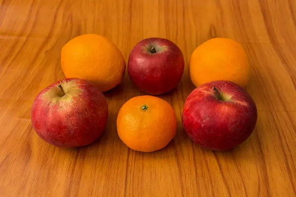 Яблоки и апельсины на коричневом фоне — стоковое фото