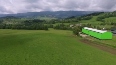 Havadan görünümü. Gün batımı. Bir yeşil çimenli tepe üzerinde uçuş.