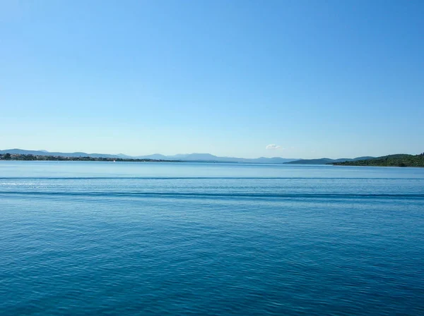 Schöne ruhige See mit Fels und Berg am blauen Himmel und sonnigem Tag — Stockfoto