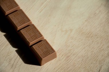 Tahta arka planda çikolata, ahşap zeminde çikolata parçaları