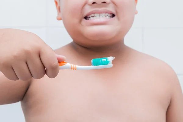 Mão menino segurando escova de dentes velha — Fotografia de Stock