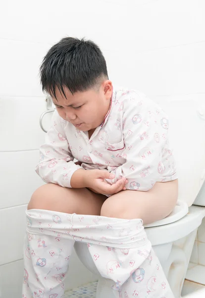 Fat boy sitting on the toilet. — Stock Photo, Image