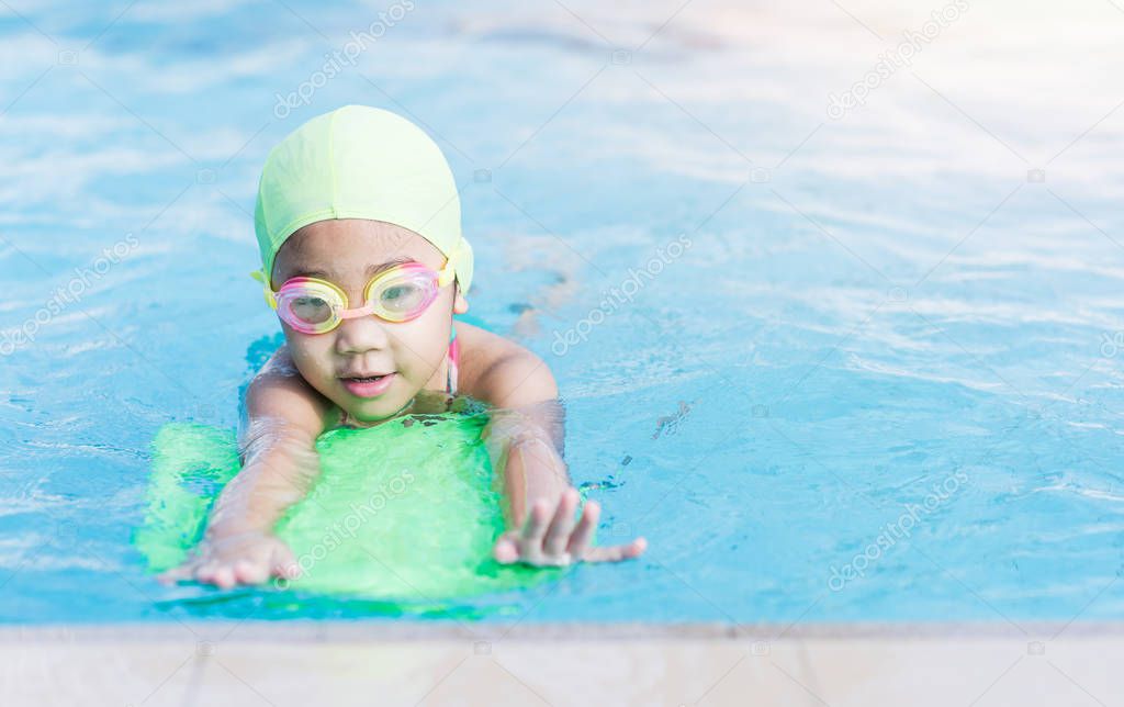 cute little girl learning how to swim