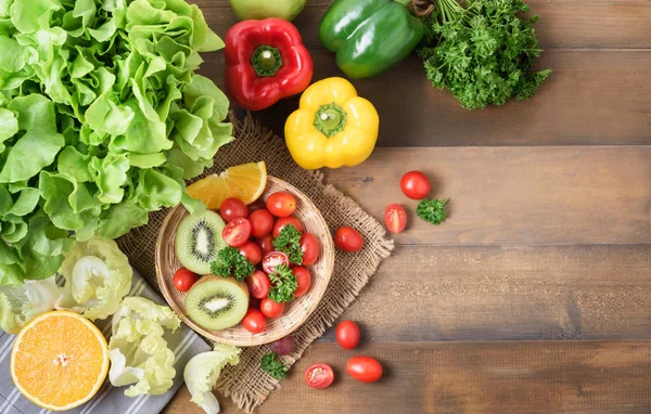 Ensalada fresca de verduras y frutas sobre fondo de madera . — Foto de Stock