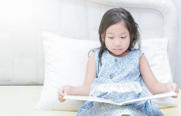 Χαριτωμένο μικρό ασιατικό κορίτσι στο Νυχτικό διαβάζοντας ένα βιβλίο. — Φωτογραφία Αρχείου