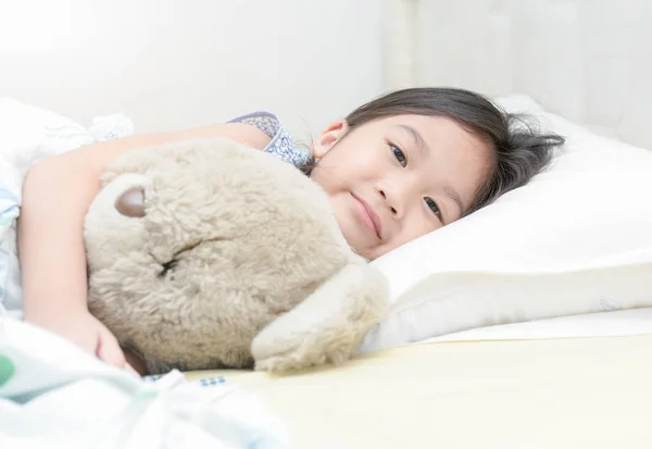 Schattig klein Aziatisch meisje glimlach en teddy bear knuffel — Stockfoto