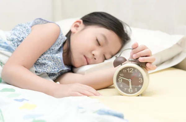 Hand girl reaching out for alarm clock — Stock Photo, Image
