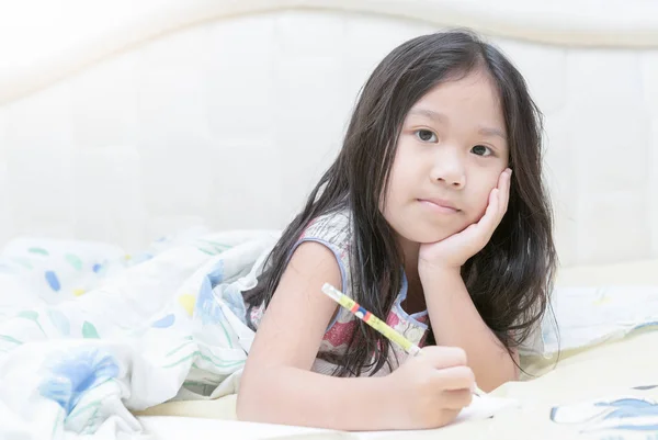 Ázsiai lány az ágyon napló írása — Stock Fotó