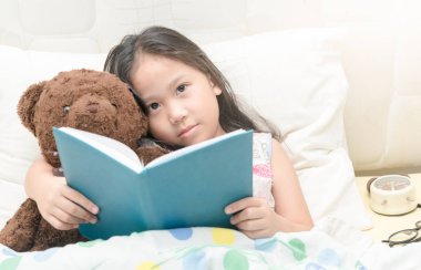 Şirin Asyalı kız teddy b ile bir kitap okuma nightdress